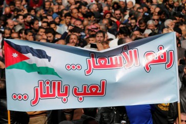 Protesters from the Islamic Action Front and others chant slogans during a protest against rising prices and the imposition of more taxes, after the Friday prayer in Amman, Jordan, February 24, 2017. The sign reads "raise prices ... playing with fire". REUTERS/Muhammad Hamed