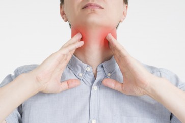 Sore throat, men with pain in neck, gray background, studio shot